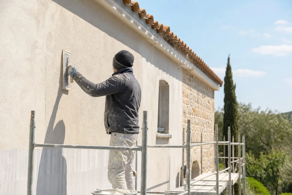 Façadier appliquant un enduit de finition sur une façade méditerranéenne